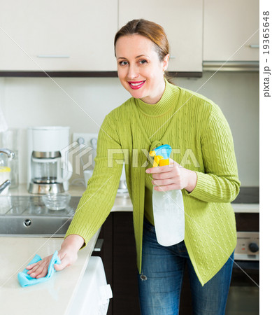 Housewife cleaning furniture in kitchen 19365648