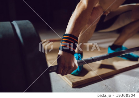 Athlet preparing for barbell exercises Athlet preparing for barbell exercises 19368504