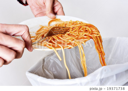 young man throwing leftovers to the trash bin 19371738