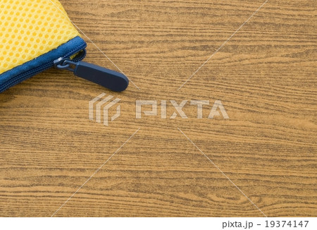 Yellow Bag with Blue Zipper on Wooden Table 19374147