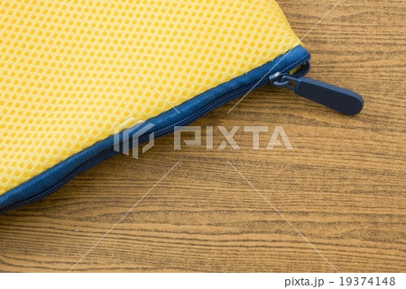 Yellow Bag with Blue Zipper on Wooden Board 19374148