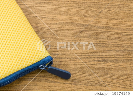 Yellow Bag with Blue Zipper on A Wooden Table 19374149