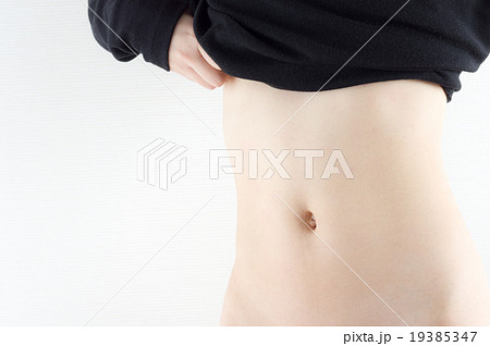 女性の細いお腹 ダイエットイメージ 上着をめくるの写真素材