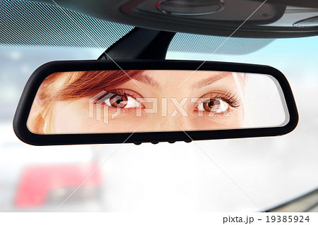 woman looks to rear-view mirror 19385924