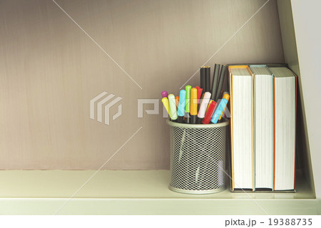 Colorful pen in metal pen pot and books on shelve Colorful pen in metal pen pot and books on shelve 19388735