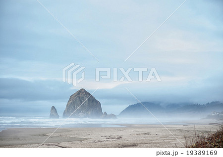 Gorgeous hill in see surrounded by fog 19389169