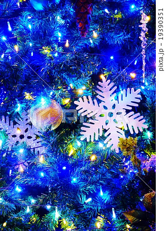 クリスマスイメージ クリスマスツリーの白系雪の結晶 青系ベタ縦位置の写真素材