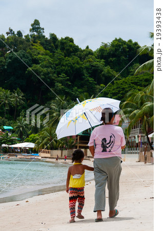 Mom and Daughter Walking on the white sand beach Mom and Daughter Walking on the white sand beach 19393438