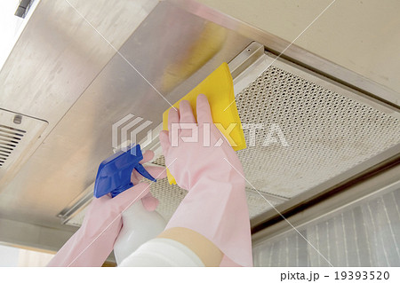 洗剤をスプレーで吹きながらレンジフードを掃除するイメージ 洗剤をスプレーで吹きながらレンジフードを掃除するイメージ 19393520