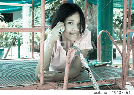 cute asian girl play phone at playground 19407561