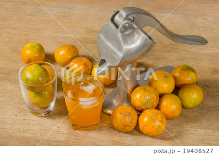 Glass of orange juice and Juicer  on wooden table 19408527