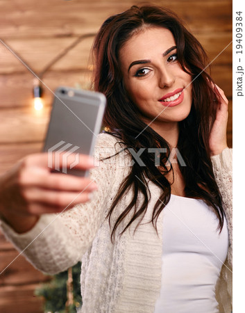 Portrait of a beautiful brunette taking a selfie Portrait of a beautiful brunette taking a selfie 19409384