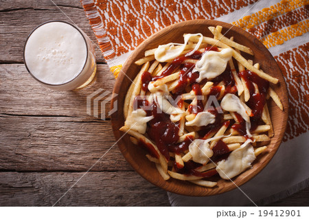 poutine and beer close-up. horizontal top view 19412901