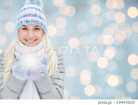 smiling young woman in winter clothes over lights 19443020