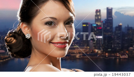 happy woman with diamond earring over night city 19443037