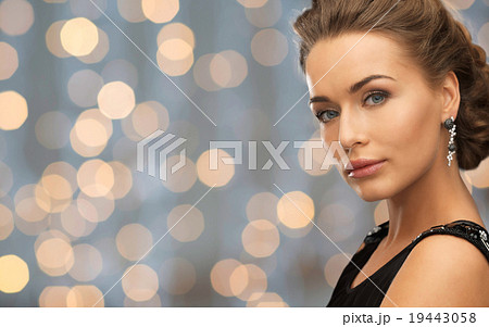 beautiful woman wearing earrings over lights 19443058