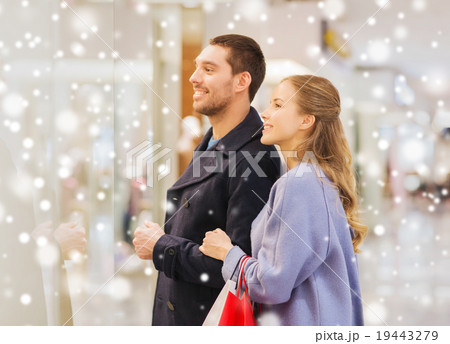 happy young couple with shopping bags in mall 19443279