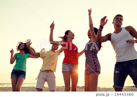 smiling friends dancing on summer beach smiling friends dancing on summer beach 19443360