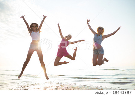 happy female friends dancing and jumping on beach happy female friends dancing and jumping on beach 19443397