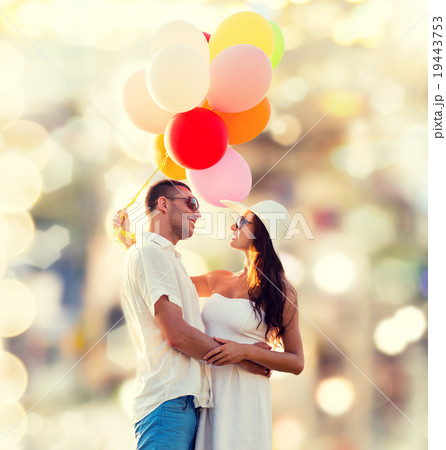 smiling couple with air balloons outdoors 19443753