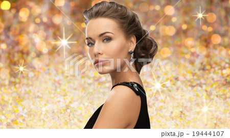 beautiful woman wearing earrings over lights beautiful woman wearing earrings over lights 19444107