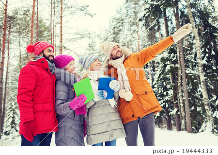 smiling friends with tablet pc in winter forest 19444333