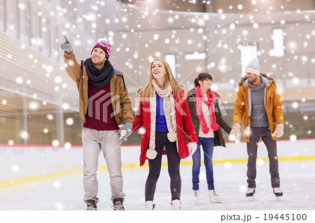happy friends pointing finger on skating rink 19445100