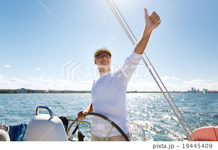 senior man at helm on boat or yacht sailing in sea senior man at helm on boat or yacht sailing in sea 19445409