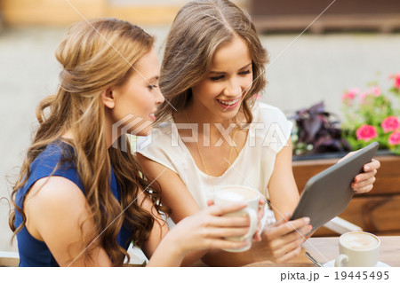 young women with tablet pc and coffee at cafe young women with tablet pc and coffee at cafe 19445495