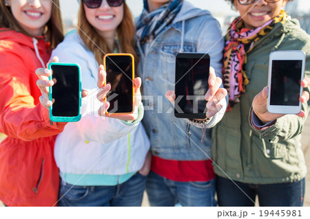close up of friends showing smartphone screens close up of friends showing smartphone screens 19445981