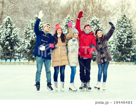 happy friends ice skating on rink outdoors 19446483