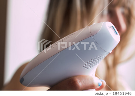 woman holding a appliance for photo-epilation 19451946