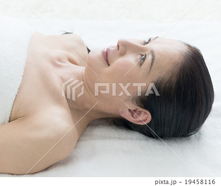 エステ　仰向けの50代女性　バスタオル 19458116