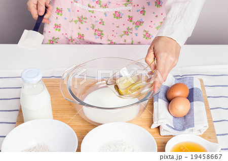Woman baking healthy muffin with olive oil 19458667