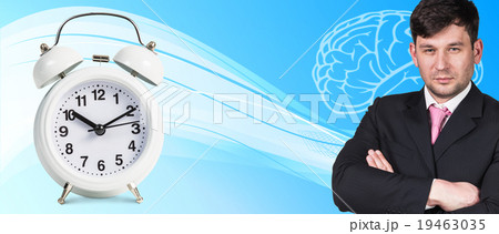 Businessman near classical alarm clock Businessman near classical alarm clock 19463035