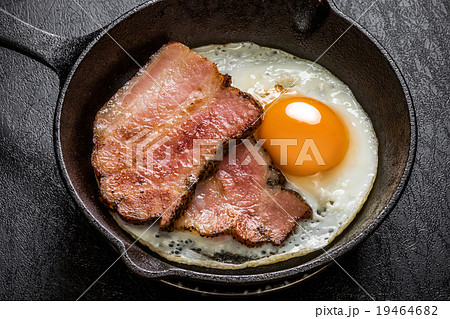 スキレットの厚切りベーコンエッグ Bacon And Eggs And Iron Fry Panの写真素材