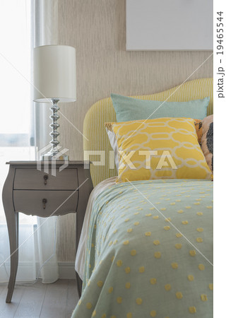 colorfull pillows on green bed with white lamp 19465544