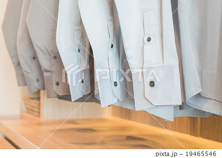 shirts hanging on rack in wooden wardrobe 19465546