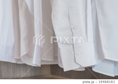 shirts hanging on rack with white buttons shirts hanging on rack with white buttons 19468161