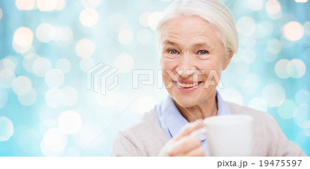 happy senior woman with cup of tea or coffee 19475597