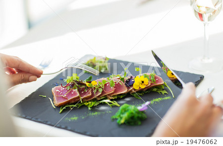 close up of woman eating salad at restaurant 19476062