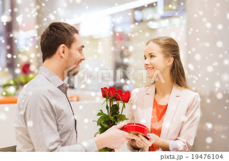 happy couple with present and flowers in mall happy couple with present and flowers in mall 19476104