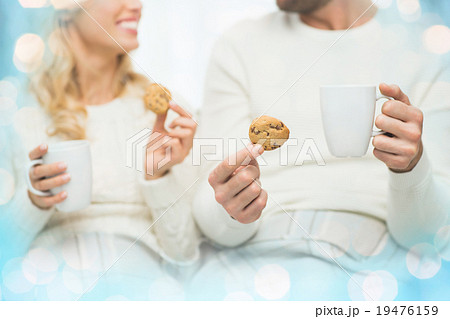 close up of happy couple with cookies and tea cups close up of happy couple with cookies and tea cups 19476159