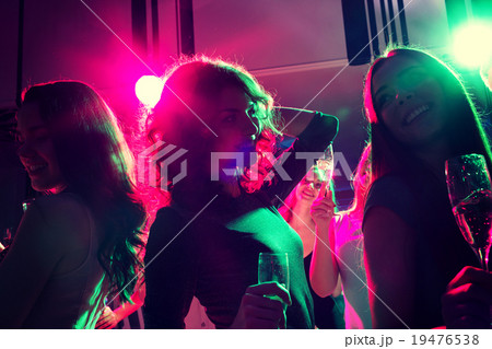 smiling friends with glasses of champagne in club smiling friends with glasses of champagne in club 19476538