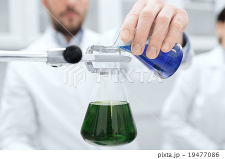 close up of scientist filling test tubes in lab close up of scientist filling test tubes in lab 19477086