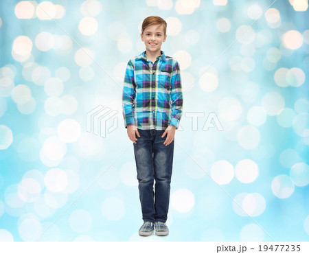 happy boy in checkered shirt and jeans over lights 19477235