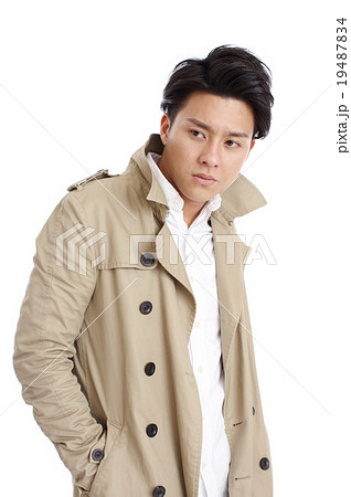トレンチコートを着た若い男性の写真素材
