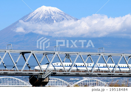 雪を被った富士山をバックに富士川橋梁を渡る新幹線の写真素材