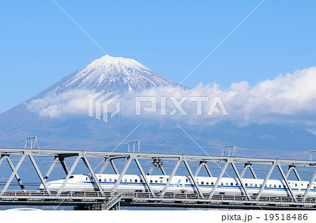 雪を被った富士山をバックに富士川橋梁を渡る新幹線の写真素材