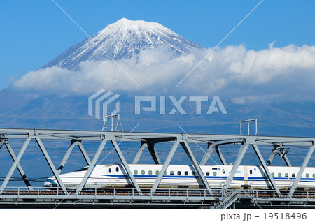 雪を被った富士山をバックに富士川橋梁を渡る新幹線の写真素材